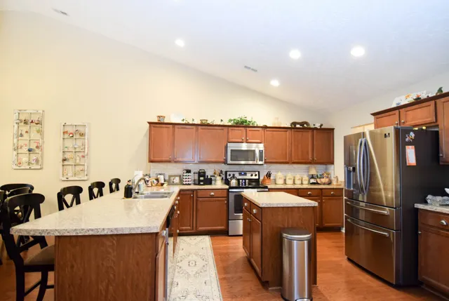 a kitchen with refrigerator and chairs