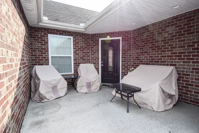 a building outdoor space with patio furniture and potted plants