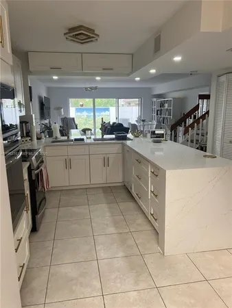a kitchen with stainless steel appliances a sink a stove a refrigerator and cabinets
