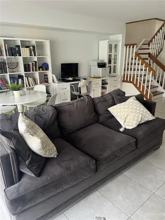 a living room with furniture and a floor to ceiling window