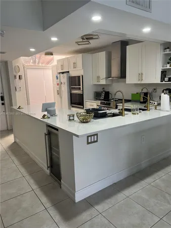 a kitchen with a sink a stove top oven and cabinets