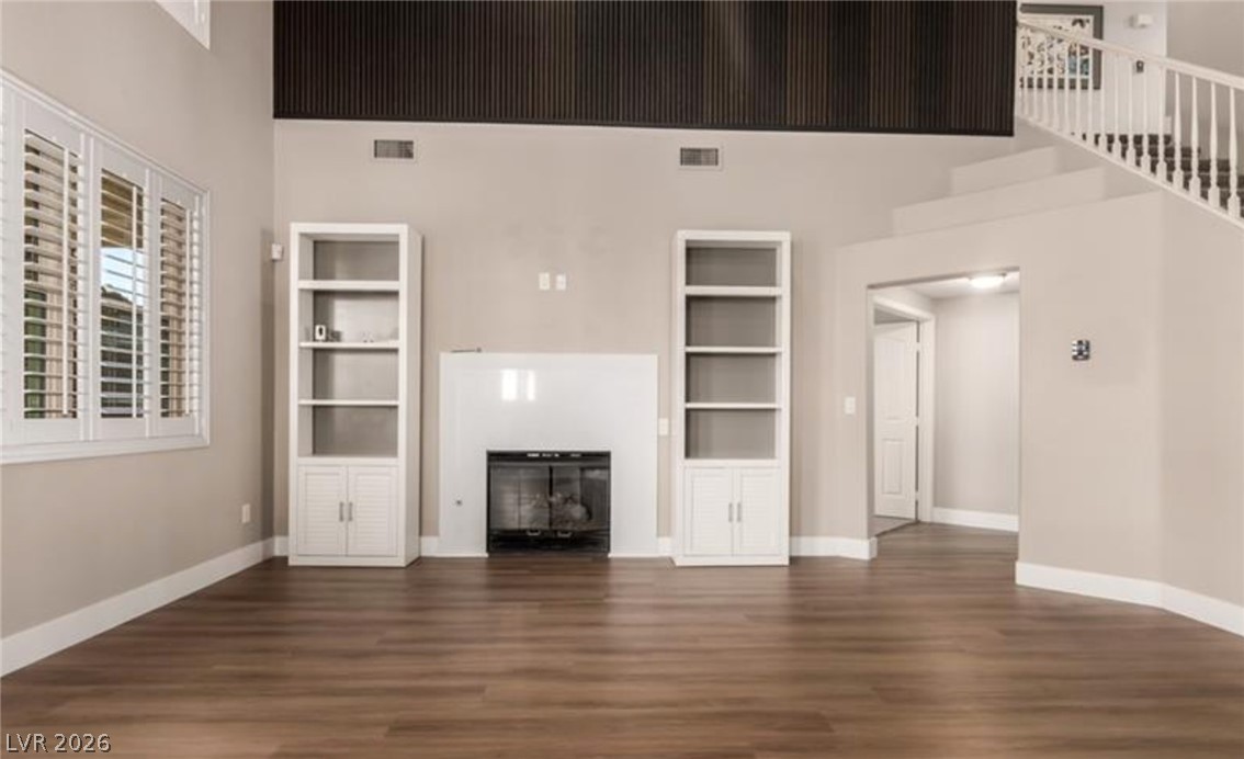 264 Pointe Ranier Avenue Henderson, NV 89012 - Photo 4 of 43 A striking fireplace with built-in shelving anchors this welcoming living area, complemented by hardwood flooring.