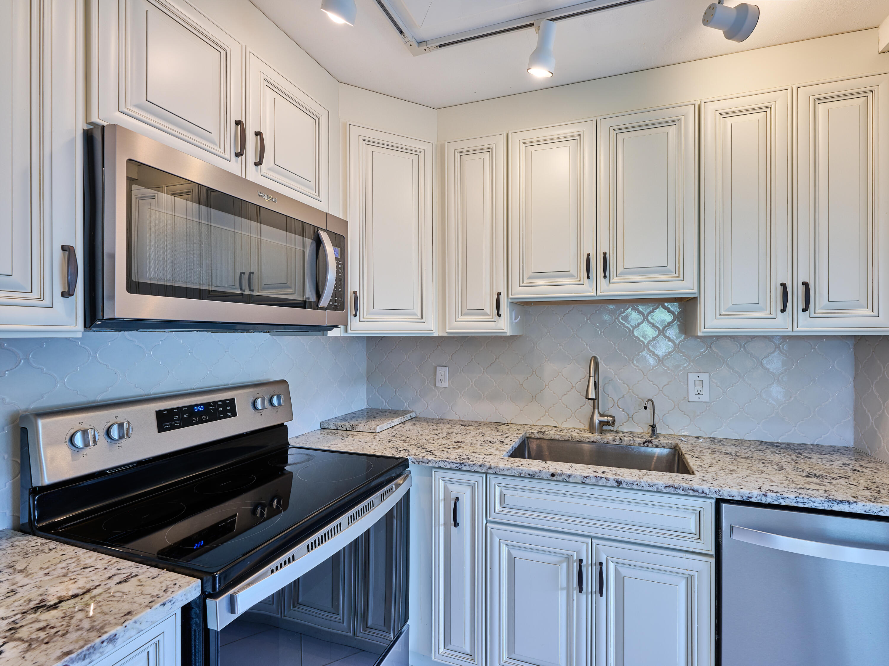 a kitchen with stainless steel appliances granite countertop a stove a microwave and cabinets