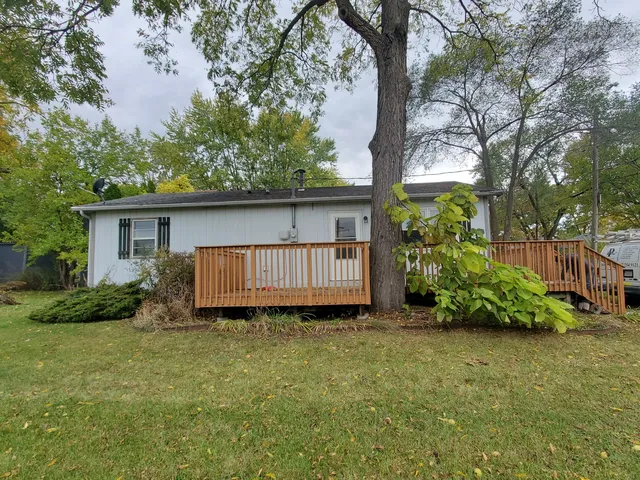a backyard of a house with potted plants and large tree