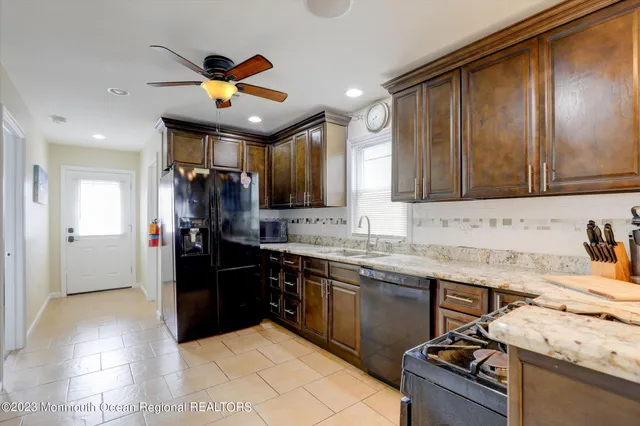 a kitchen with stainless steel appliances granite countertop a sink stove and refrigerator