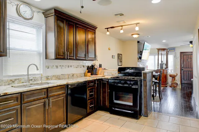 a kitchen with stainless steel appliances granite countertop a stove a sink and a refrigerator