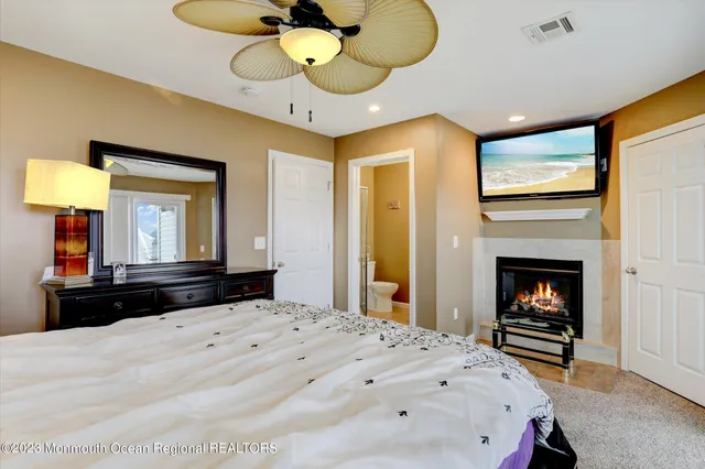a bedroom with a bed and a fireplace with a large mirror