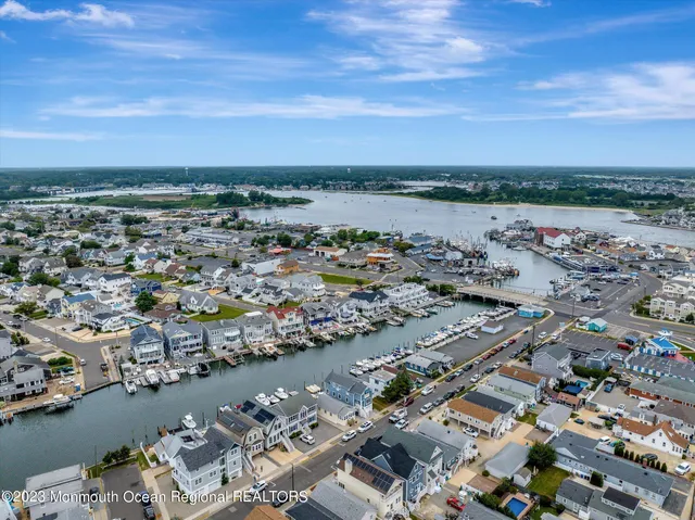 an aerial view of a city with lots of residential buildings and ocean view in back