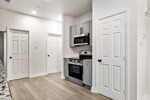 a kitchen with white cabinets and stainless steel appliances