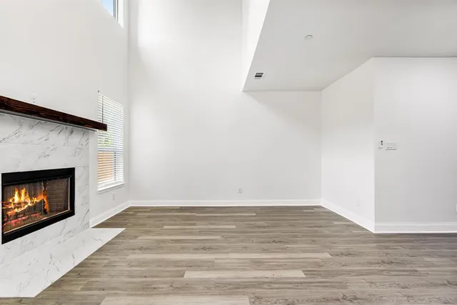 a view of a livingroom with wooden floor and a fireplace