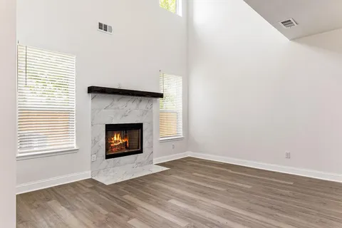 a view of a room with wooden floor and a fireplace