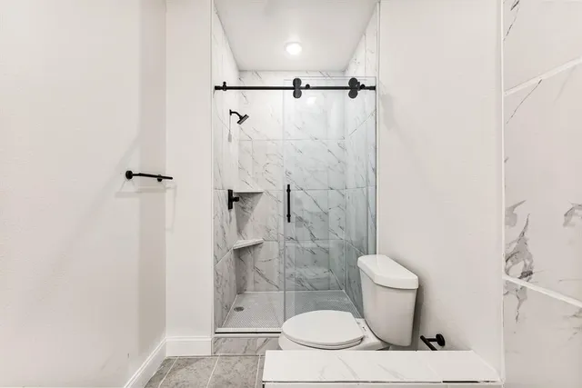a bathroom with a toilet and a shower