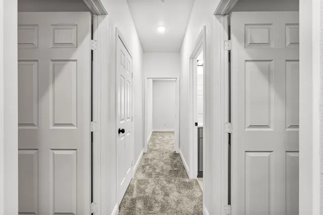 a view of a hallway with wooden floor and closet area