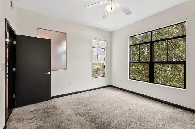 an empty room with windows and closet