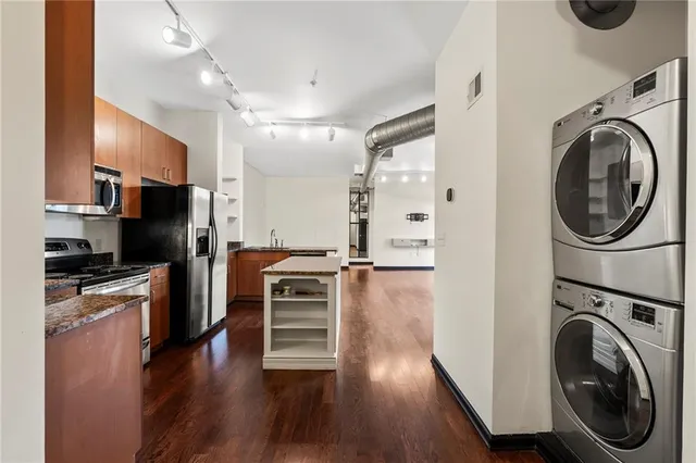 a view of a kitchen with a stove top oven a refrigerator and cabinets