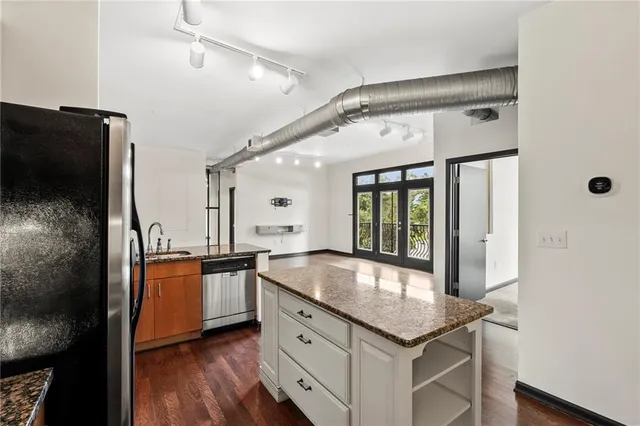 a kitchen with stainless steel appliances granite countertop a sink and a refrigerator
