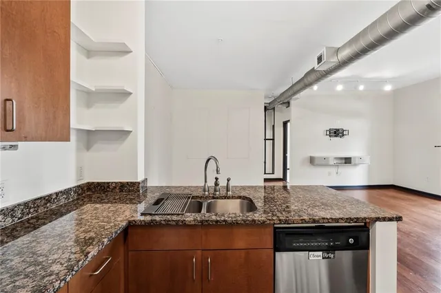 a kitchen with granite countertop a sink and cabinets