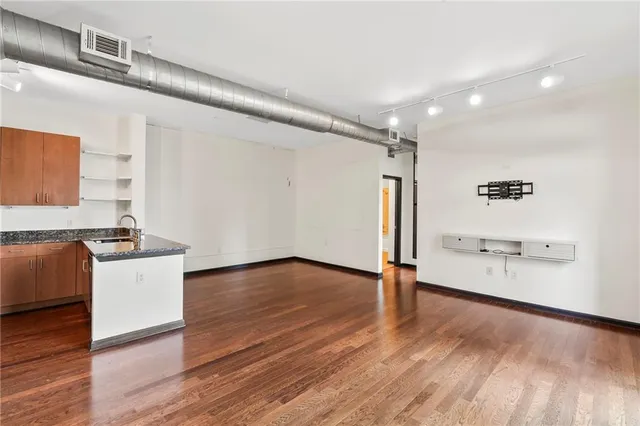 a view of an empty room with wooden floor