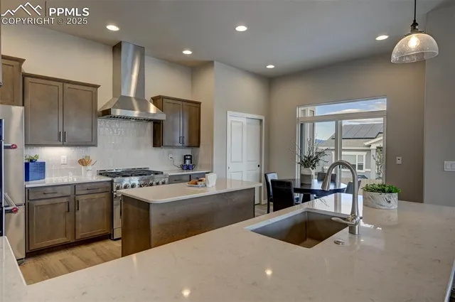 a kitchen with stainless steel appliances granite countertop a sink a stove and a refrigerator