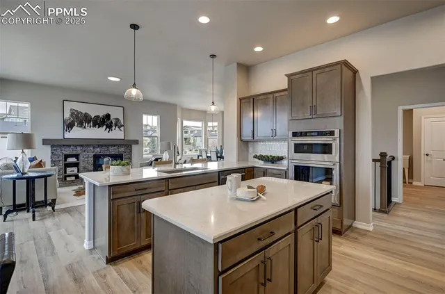 a kitchen with a sink a center island cabinets and stainless steel appliances
