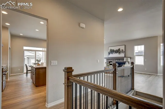 a view of a hallway with wooden floor and windows