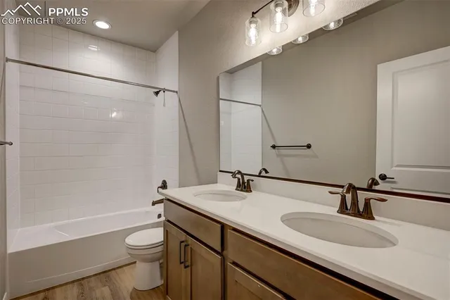 a bathroom with a sink a toilet a mirror and shower