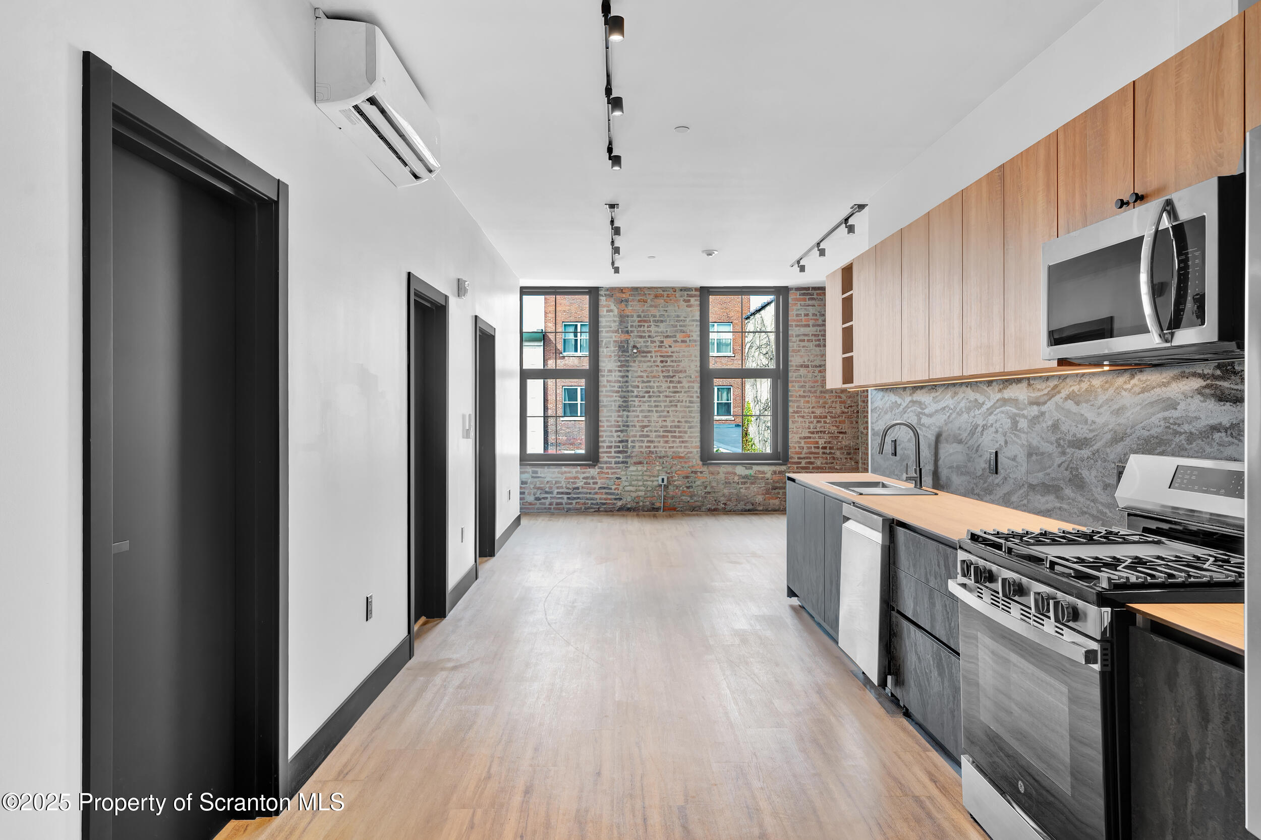 115 Penn Avenue, Unit 202 Scranton, PA 18503 - Photo 31 of 60 a kitchen with stainless steel appliances a stove top oven a sink dishwasher a refrigerator and a oven with wooden floor
