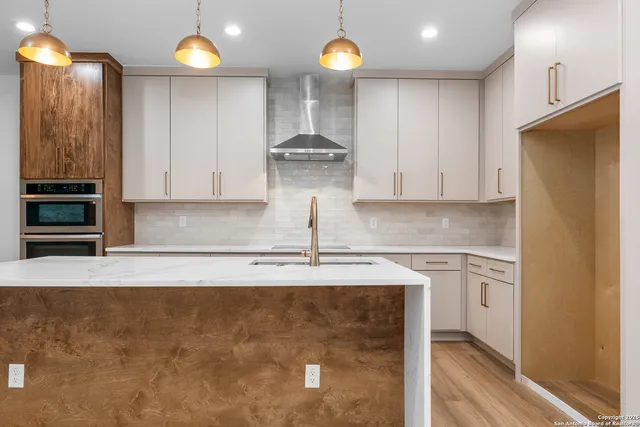 a kitchen with stainless steel appliances granite countertop a sink a stove and a refrigerator