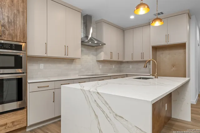 a kitchen with stainless steel appliances granite countertop a sink stove and cabinets