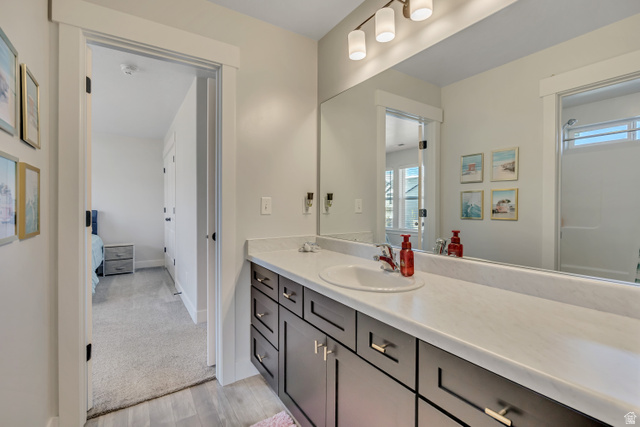 1577 Quailhill Road Saratoga Springs, UT 84045 - Photo 26 of 46 Jack and Jill bathroom with vanity, ensuite bath, light wood-style flooring, light carpet, and a shower
