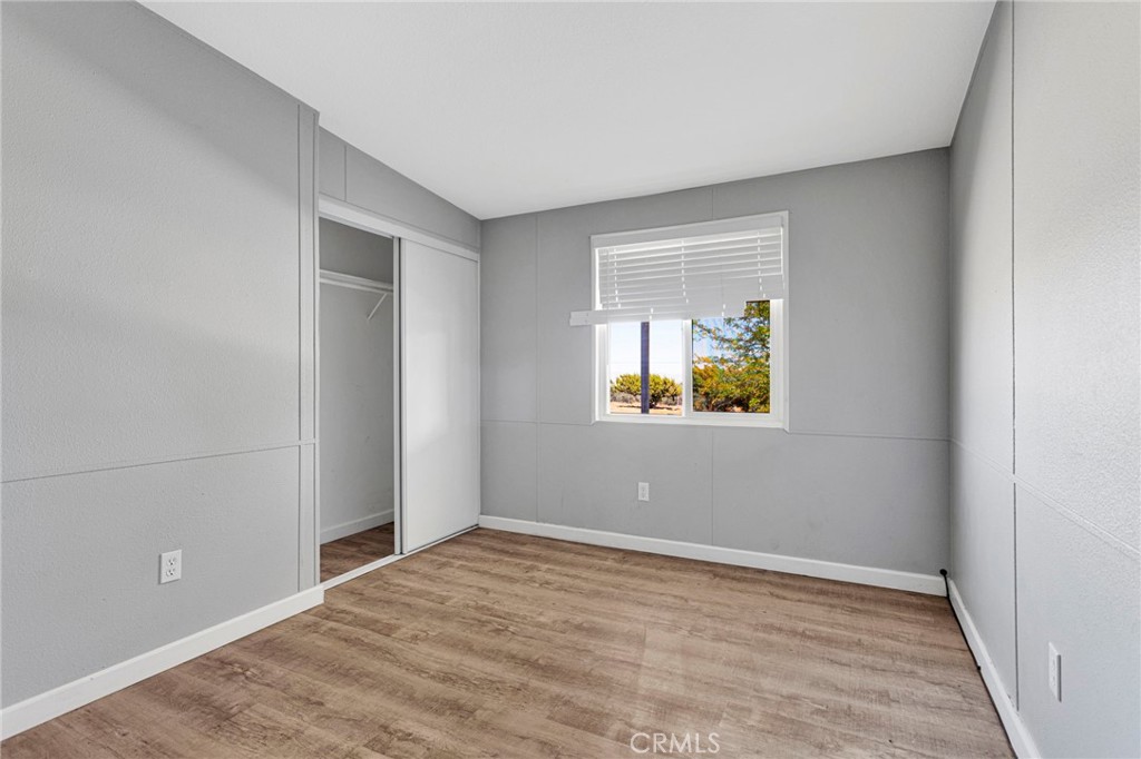 8074 Mira Mar Road Phelan, CA 92371 - Photo 18 of 49 a view of an empty room with window and wooden floor
