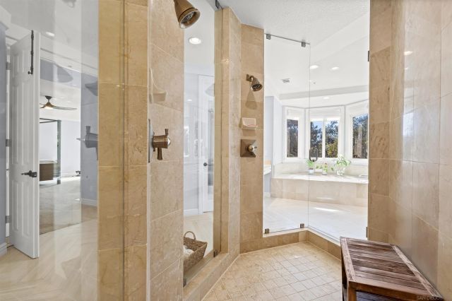 a view of a patio with couches table and chairs under an umbrella with a fire pit