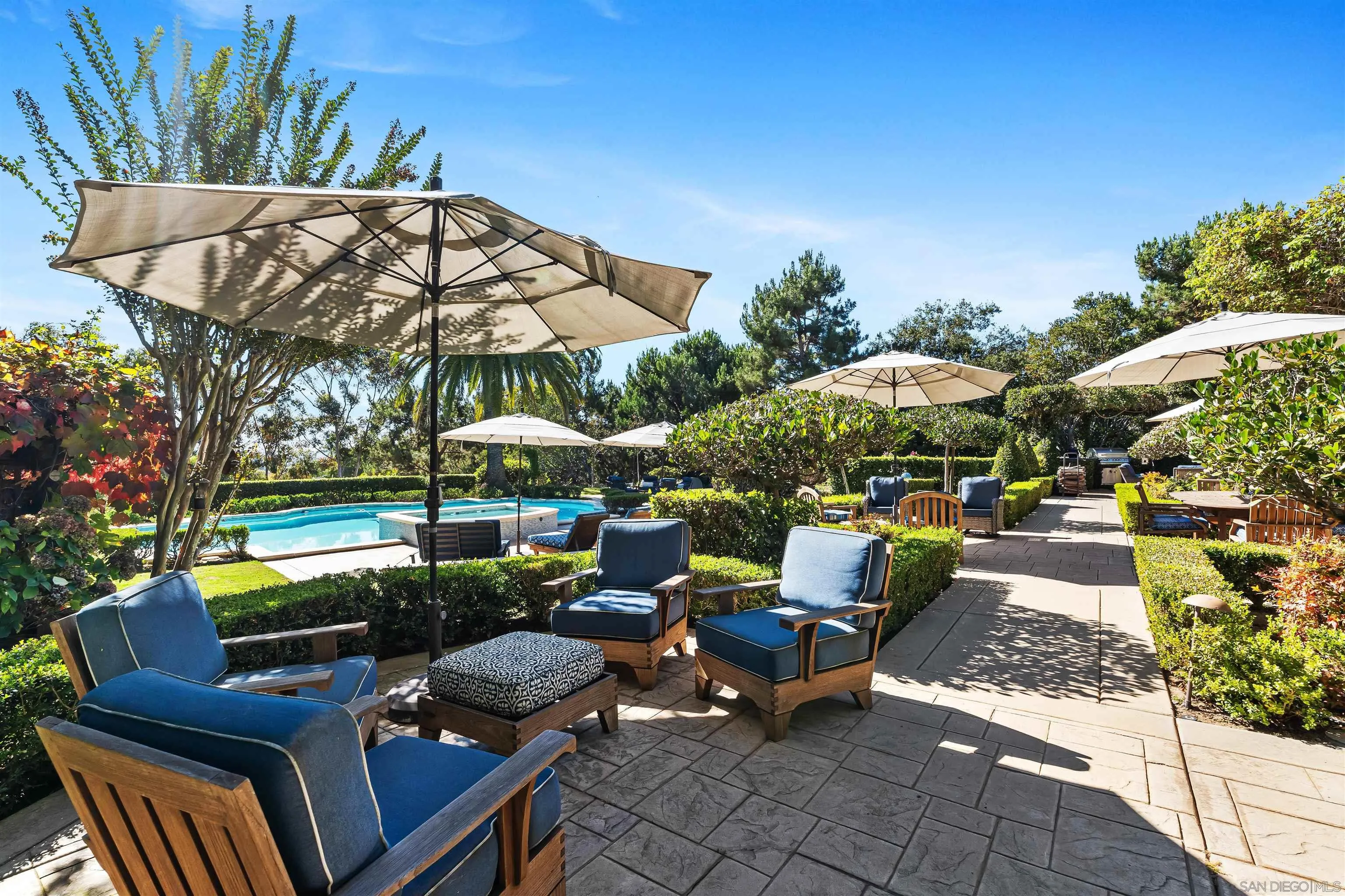 301 Cantle Lane Encinitas, CA 92024 - Photo 50 of 75 a view of a patio with couches table and chairs under an umbrella with a fire pit