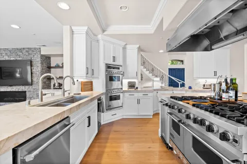 a kitchen with stainless steel appliances granite countertop a sink cabinets and a refrigerator
