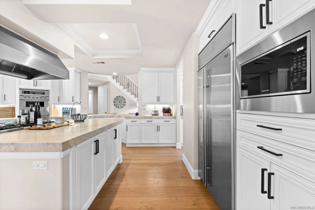 a kitchen with stainless steel appliances kitchen island a sink and a refrigerator