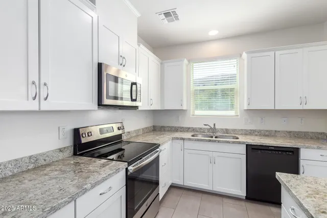 a kitchen with granite countertop sink and refrigerator