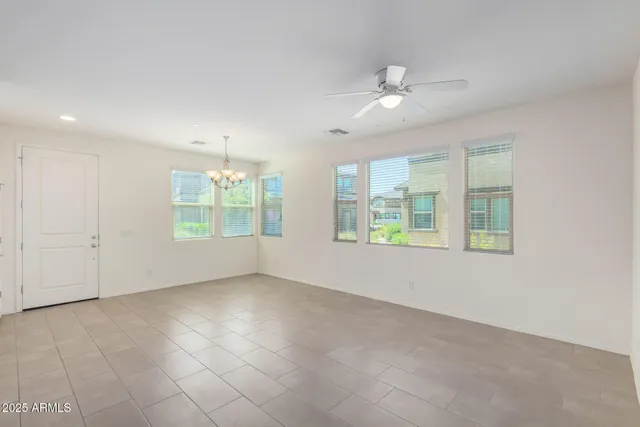 en empty room with windows and chandelier