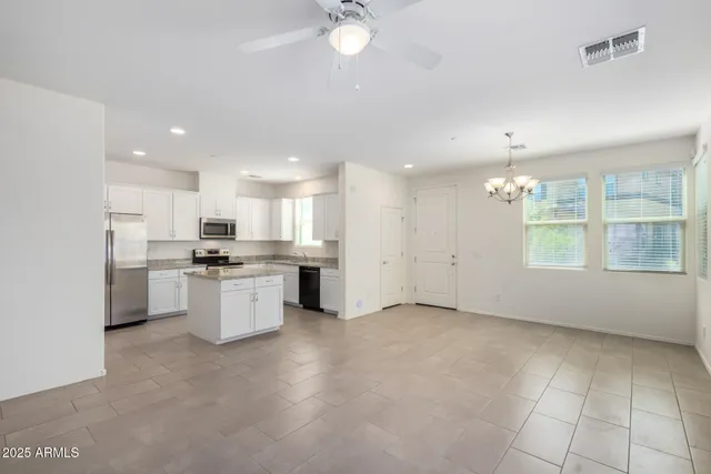 en empty room with windows and ceiling fan