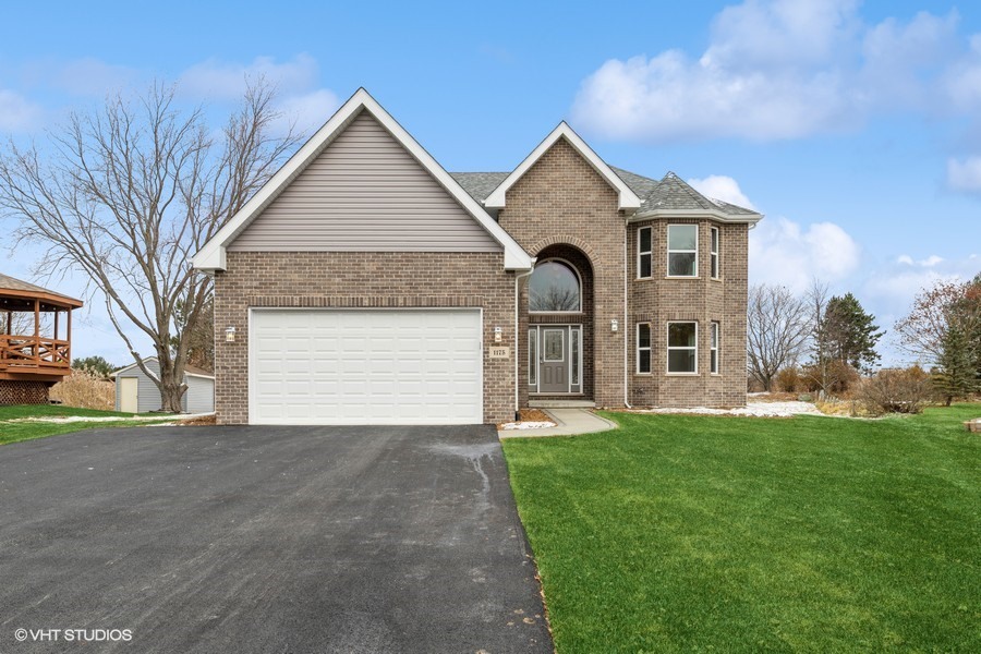 a front view of a house with a yard and garage