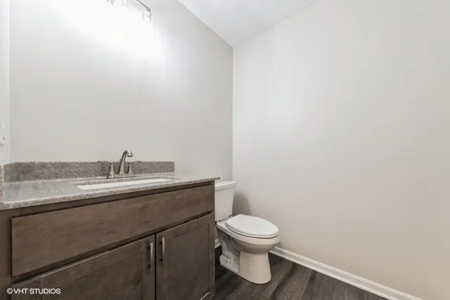 a bathroom with a granite countertop toilet and sink