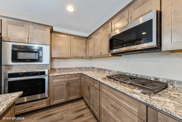 a kitchen with stainless steel appliances a stove a microwave a sink and cabinets