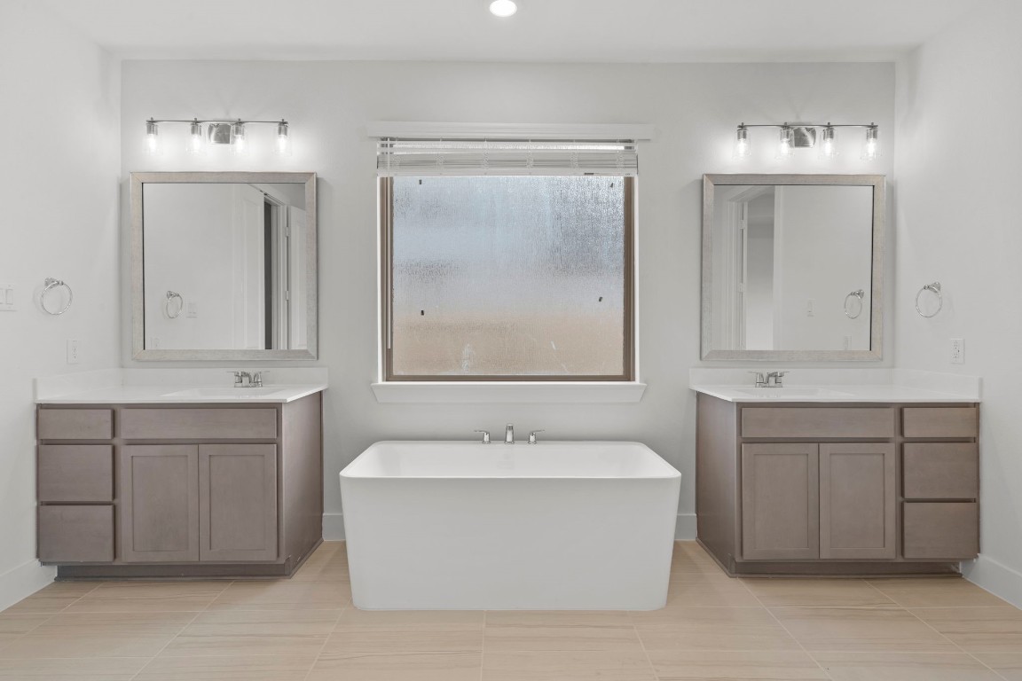 644 Cross Timbers Trace Waller, TX 77484 - Photo 17 of 33 a bathroom with a bathtub a sink a mirror and a window
