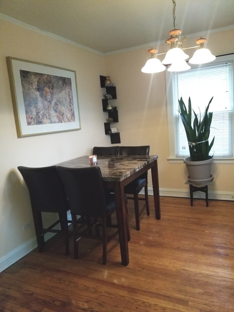 10637 South Normal Avenue Chicago, IL 60628 - Photo 4 of 8 a view of a dining room with furniture and wooden floor