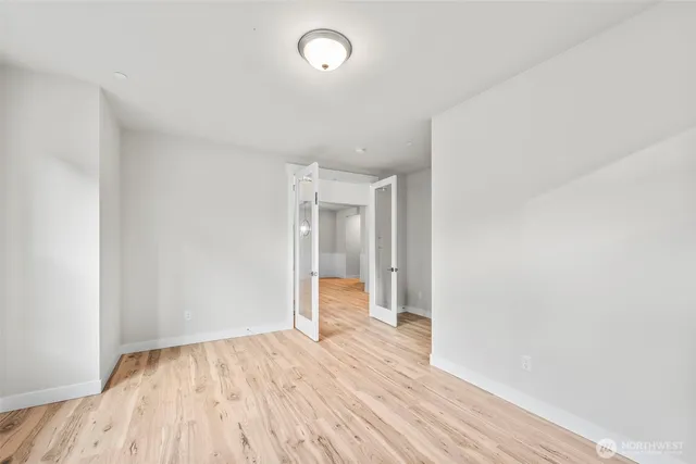 a view of empty room with wooden floor