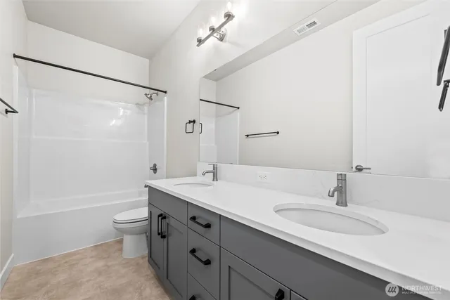 a bathroom with a sink a toilet a shower and a mirror