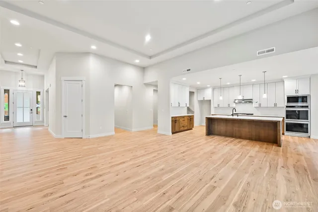 a large kitchen with kitchen island a sink stainless steel appliances and cabinets