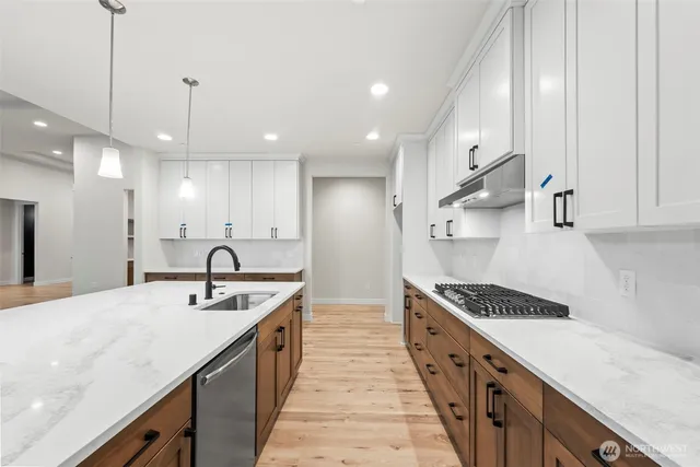 a kitchen with stainless steel appliances a sink stove and cabinets