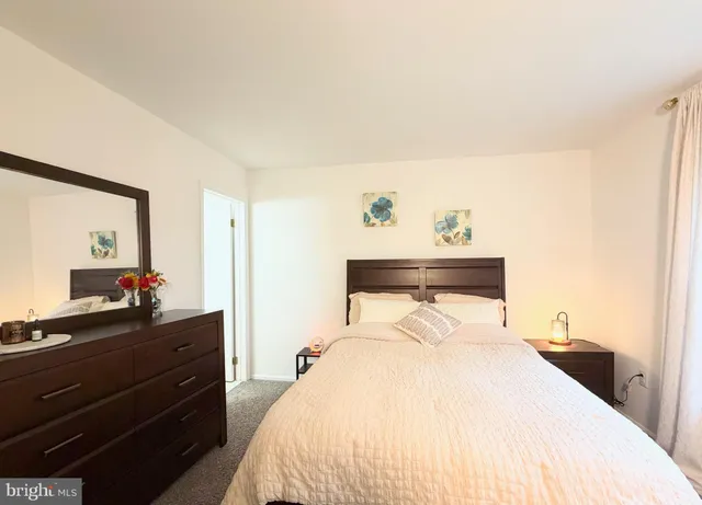 a bedroom with a bed and a mirror on dresser