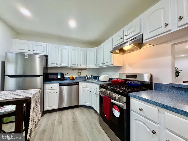 a kitchen with stainless steel appliances granite countertop a stove a refrigerator and a sink
