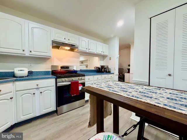 a kitchen with granite countertop white cabinets and appliances